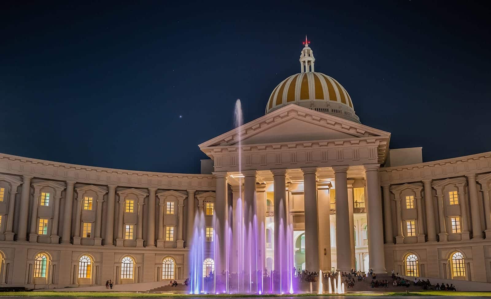 A domed building on the Infosys Mysuru campus, lit at night