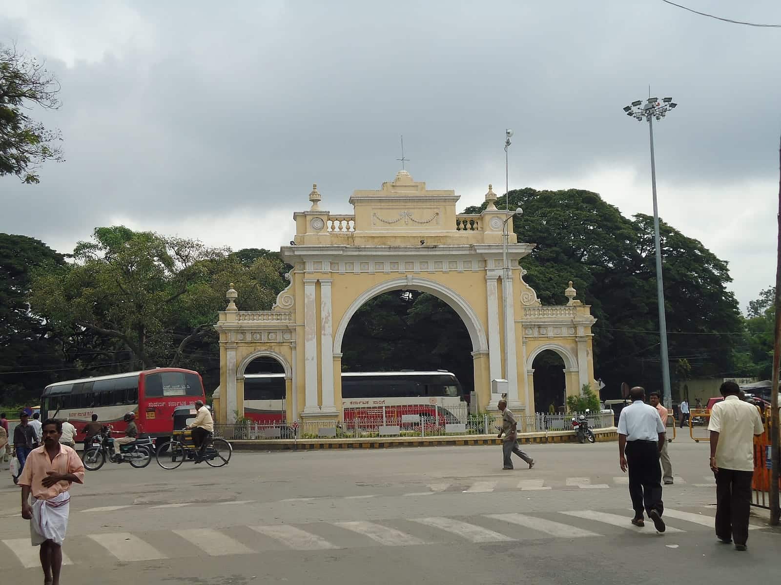 An arched gateway in Mysuru with city buses passing through