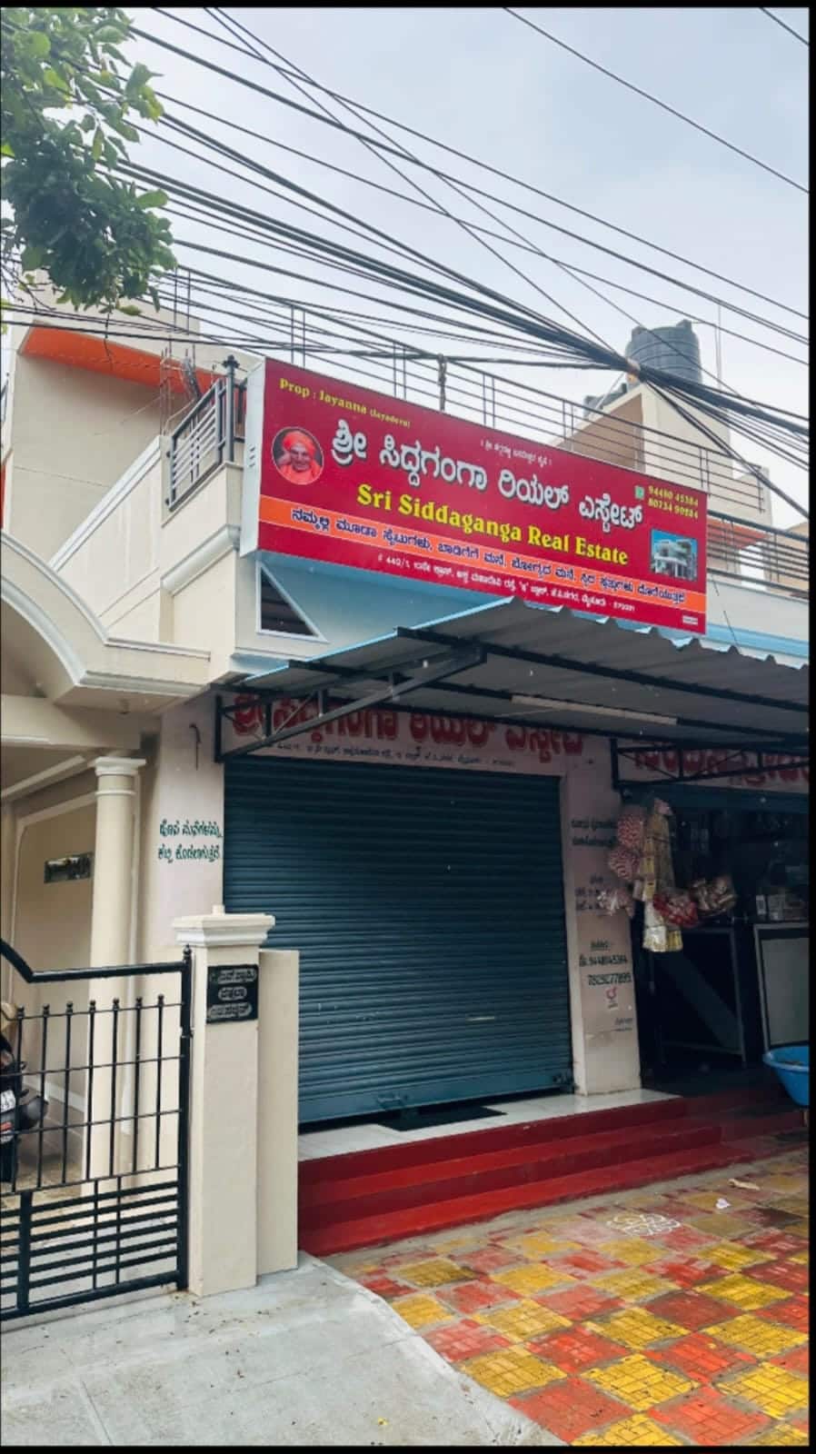 Sri Siddaganga Real Estate office front with signboard on Akkamahadevi Road, JP Nagar, Mysuru