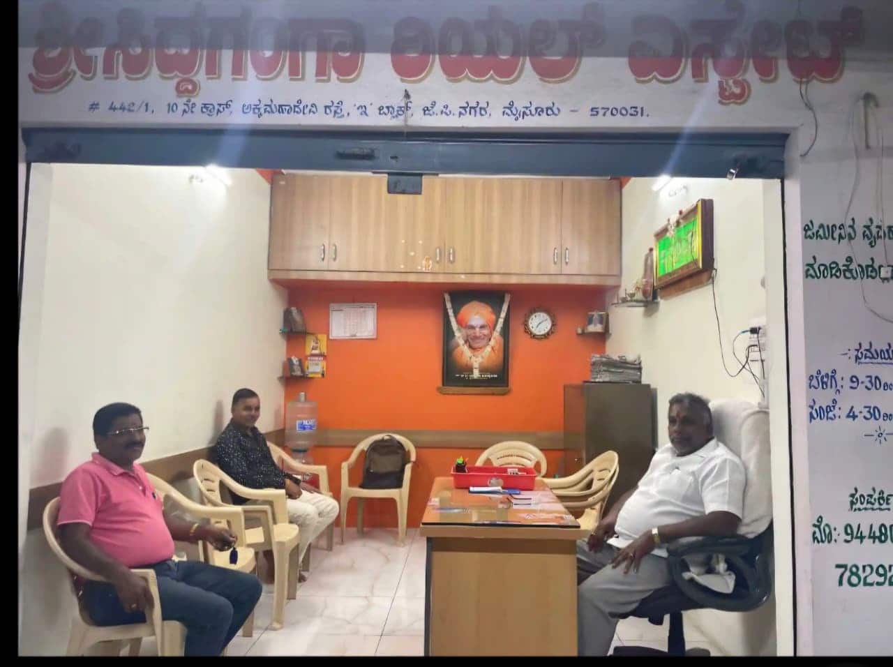 Inside the Sri Siddaganga Real Estate office in Mysuru with clients being assisted