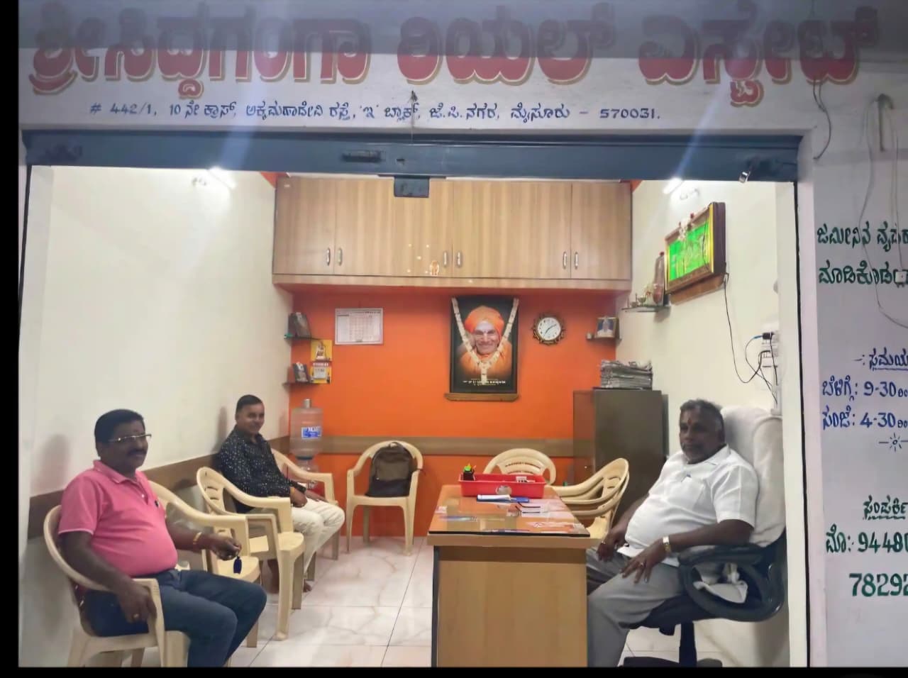 Inside the Sri Siddaganga Real Estate office in Mysuru with clients being assisted