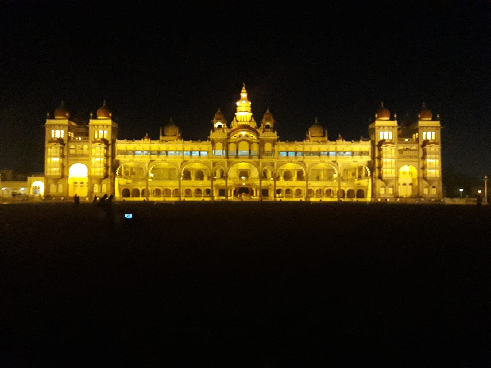 Mysore Palace outlined in lights against the night sky